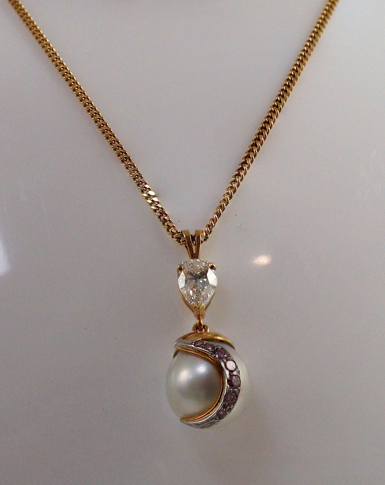 A modern gold, single stone South Sea pearl, single stone pear cut diamond and graduated seven stone pink diamond set drop pendant